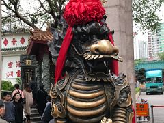 01B Foo Dog Lion statue wearing a red headdress guards the entrance to the Wong Tai Sin temple Hong Kong
